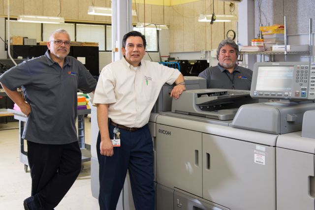 UT Print also installed a new Ricoh Pro 8120s black-and-white printer. With it here are (from left) John A. Navarro, David Vallejo and Gerard Maldonado.