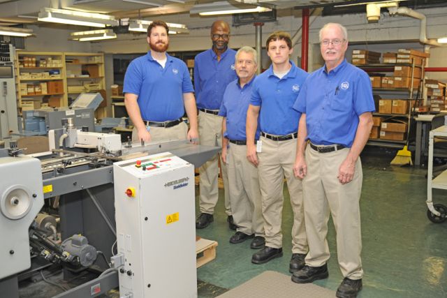 The in-plant’s bindery technicians stand with a Heidelberg Stahlfolder. From left: Jeff Poto, Butch Jenkins, Bill Tyjewski, Ben Schoultheis and Paul Taulbee (team lead).