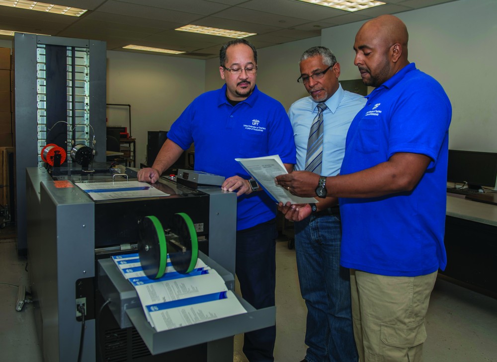  From left: Louis Lopez, Oscar Rivera and Jimmy Molina go over a job being finished on the Duplo System 5000. 