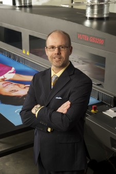 Company President Todd Meisner stands in front of the team's Vutek GS3200 wide-format digital press.